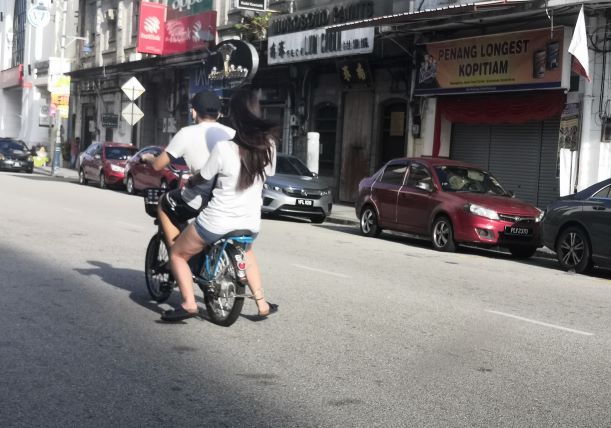 A young couple's romantic bicycle ride in Penang town
